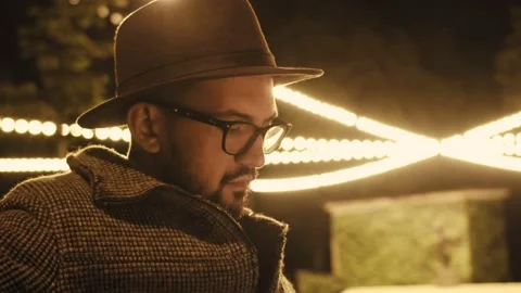 A man sits on a bench in the evening time and is not impatiently waiting for Stock Footage 166035653