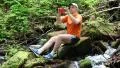 Man sits on big stone between two small waterfalls HD Footage