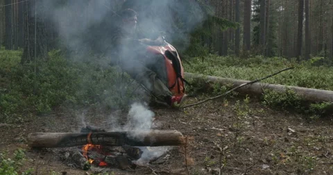 A man sits at a campfire Stock Footage 64796500