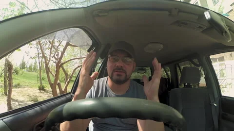 A man sits in a car and talks Stock Footage 196214545