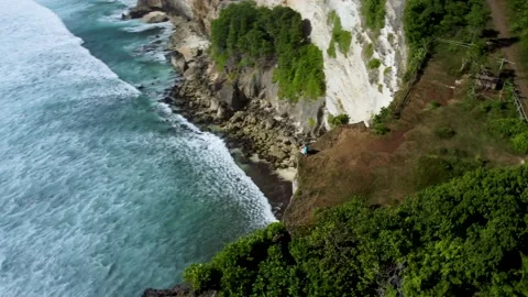 Man sits on the clifftop above ocean Stock Footage 154621553