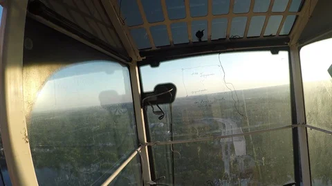 Man sits in a cockpit of high-blooded and looks down at the river and the city Stock Footage 127679779