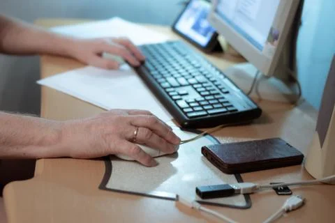 A man sits at a computer, holds a mouse in his hand, work at home during the  Фото