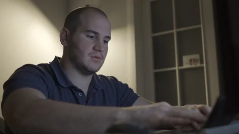 A man sits at a computer, typing and talking Stock Footage 101662545