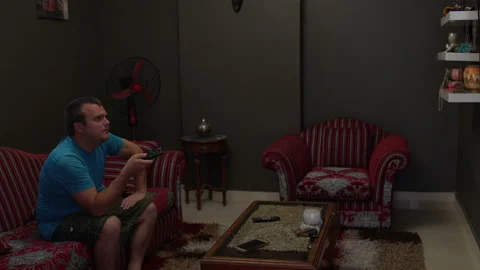 A man sits on the couch and watching tv Stock Footage 101745989