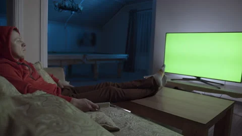Man sits on the couch at night and watches TV, chroma key Stock Footage 155314940