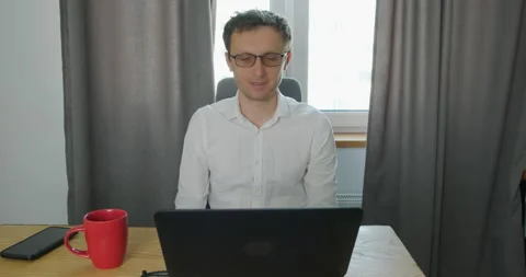 Man sits at desk in front of notebook and communicates via video call. The Vídeo Stock 199588660