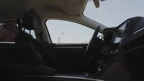 A man sits down in the car, gets in and starts a car. The businessman presses Видео 88914106