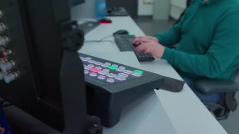 A man sits down on a chair in a TV control room, doing his job Video stock 276969731