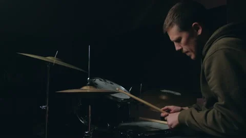 Man sits down to play the drum set Stock Footage 140742322
