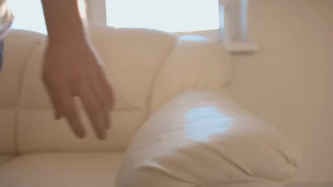 A man sits down on a sofa and takes off his medical mask Stock Footage 127669183