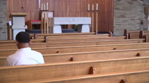 Man sits in an empty church praying Stock Footage 67383795