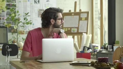 Man sits in front of laptop computer. Thinking and typing keyboard. It is Stock Footage 245426949