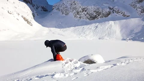 Man sits in front of winter iced lake Stock Footage 239344764