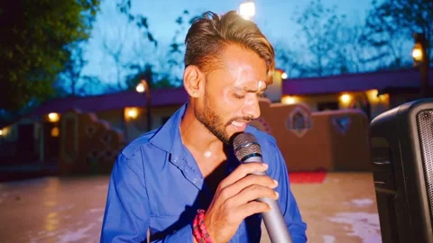 Man sits gazing down while singing into microphone Stock Footage 302074337