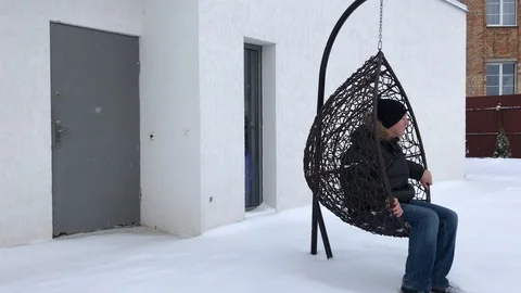 Man sits in a hammock in winter Video stock 102898970