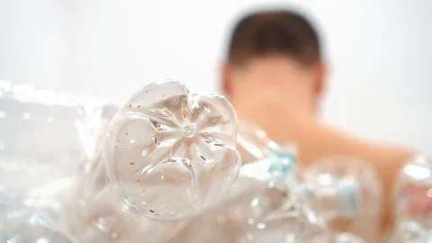 Man sits with his back in a pile of plastic Stock Footage 125329490