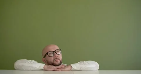 A man sits with his head on his hands and thinks Stock Footage 267087655
