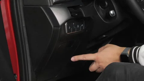 A man sits inside a car and presses various buttons, no one around, dark studio, Stock Footage 280224245