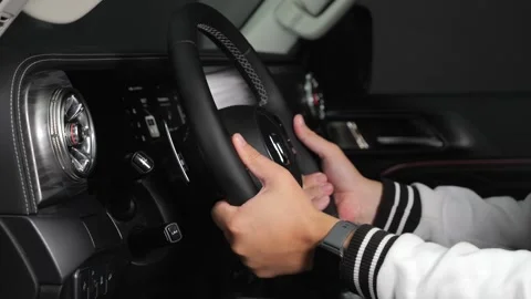 A man sits inside a car and presses various buttons, no one around, dark studio, Stock Footage 280224292