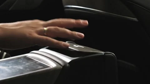 A man sits inside a car and presses various buttons, no one around, dark studio, Stock Footage 280224373