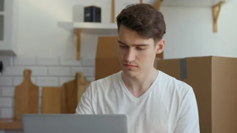 Man sits at kitchen table in new apartment opening laptop Stock Footage 201167587