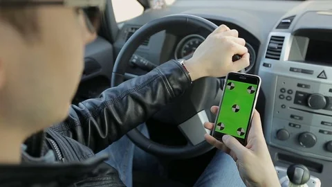 Man sits in the modern car and works on smartphone - closeup hands. Stock Footage