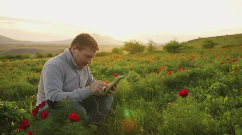 Man sits on the nature and does business conversation via tablet Stock Footage 62519079