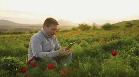 Man sits on the nature and does business conversation via tablet Stock Footage 62519101