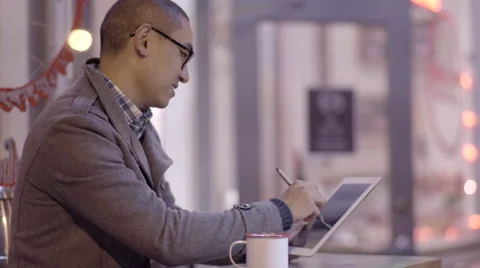 Man Sits Outside At A Cafe (At Night) And Enjoys Drawing On His Tablet (4K) Stock-Footage 52630867