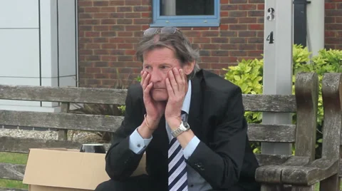 Man sits outside his work with his box of belongings Stock Footage 27329722