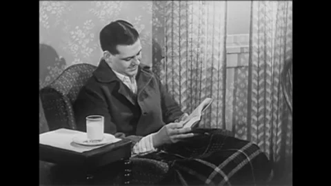 A man sits in pajamas while a short montage of video footage and text Stock Footage 146472448