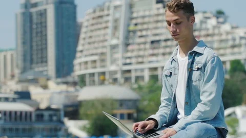 Man sits on parapet with notebook and meets dark haired lady Stock Footage 112189614