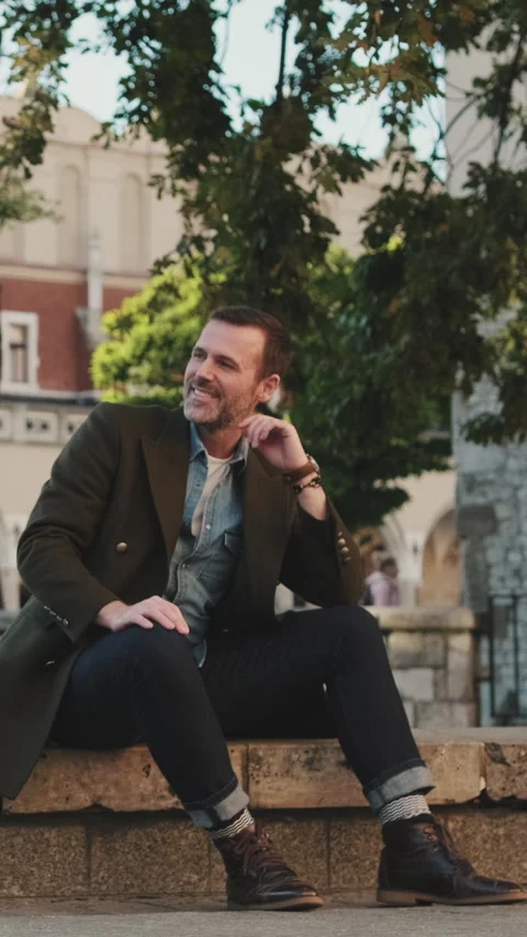 Man sits on the square of the old city Video stock 227135350