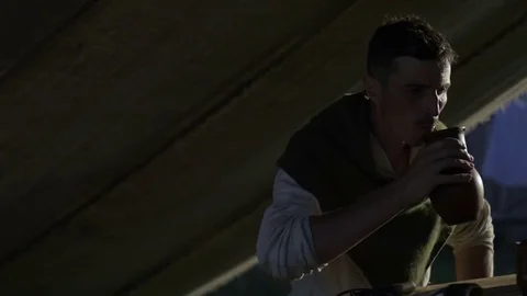 Man sits at a table and drinks water from a jug Stock Footage 82402604