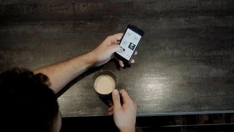 A man sits at a table and drinks coffee Stock Footage 119781653