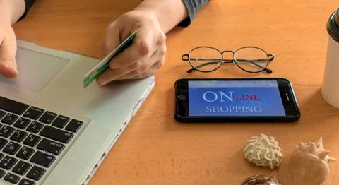 A man sits at a table and makes online shopping on the Internet 스톡 사진