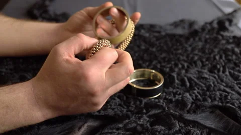 A man sits at a table and picks up jewelry and jewelry Stock Footage 130941966