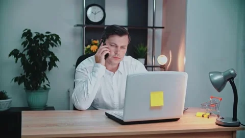 A man sits at a table and talks on the phone. Stock Footage 146264434