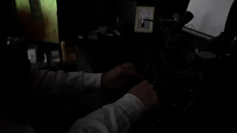 A man sits at a table and types on an old typewriter. Close-up hands. Dark Stock Footage 241738492