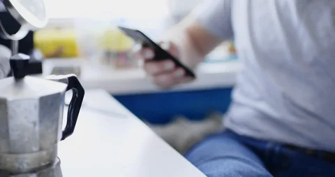 Man sits at table with smartphone and drinks fresh hot drink Vídeo Stock 105574578