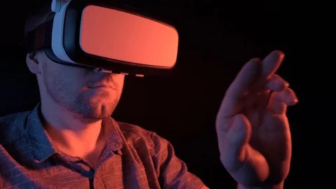 A man sits wearing glasses of virtual reality moves his hands in the air Stock Footage 115089593