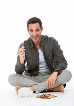 Man sitted on the floor, smiling at camera, holding a coin Stock Photos