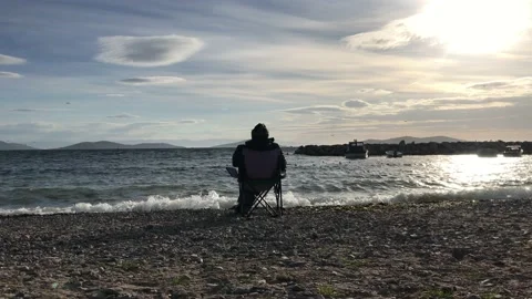 Man sitting alone on the beach Stock Footage 145897423