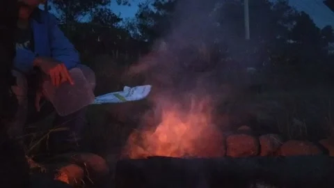 A man sitting alone in front of campfire bonfire at indonesian family fun campin Video stock 151301854