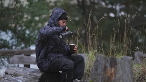 Man sitting alone in nature drinking mate, evoking solitude and introspection Stock Footage 312847649