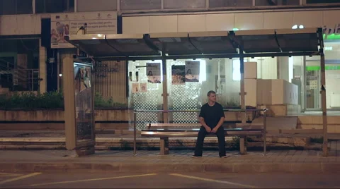 A man sitting alone at night in a bus station 库存影片 40525460