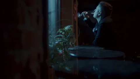 A man sitting alone at the table and drinking by the window Stock-Footage 258332446