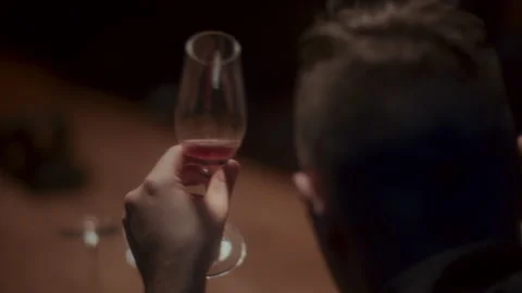 A man sitting alone at the table and holding a glass of wine Stock-Footage 258333340