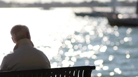 Man Sitting Alone by the Water Stock Footage 8686566